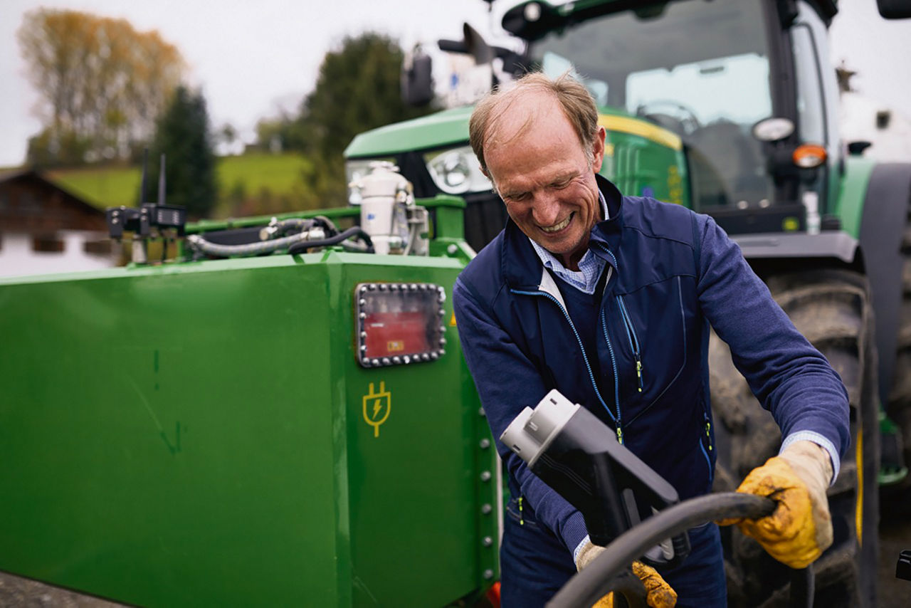Ein Bauer steht vor seinem Traktor