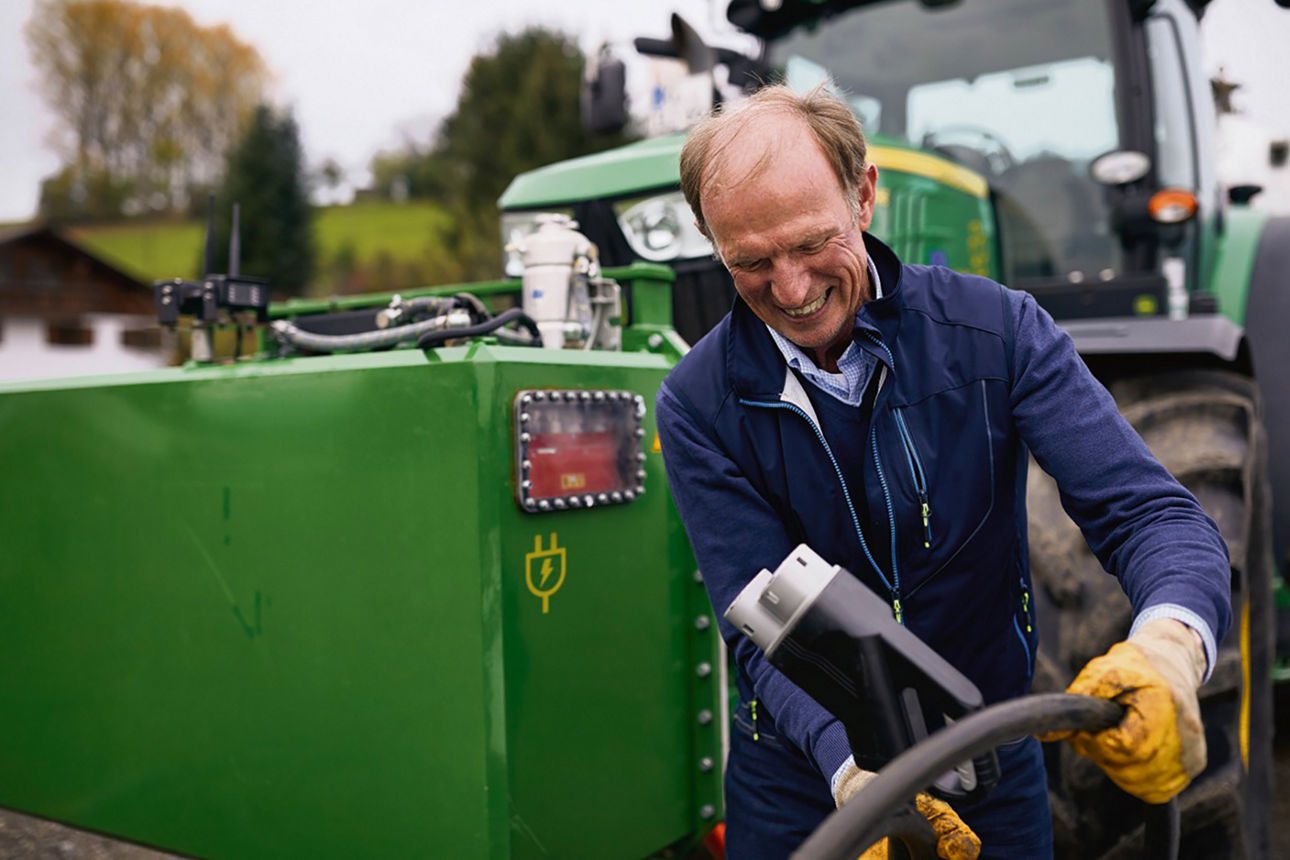 Ein Bauer steht vor seinem Traktor