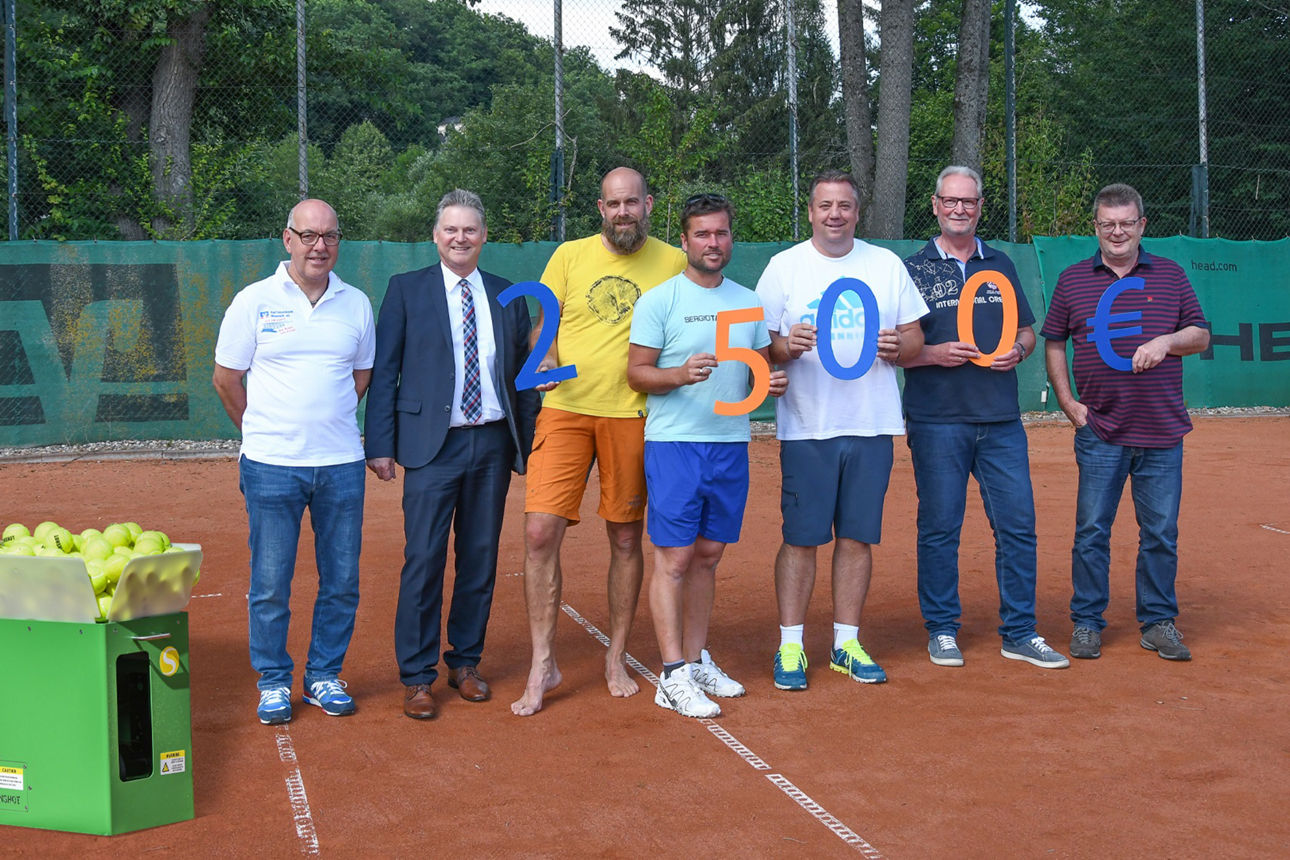 Mitglieder des Tennisclubs Neustadt und Mitarbeiter der Raiffeisenbank stehen neben einer Tennis-Ballmaschine