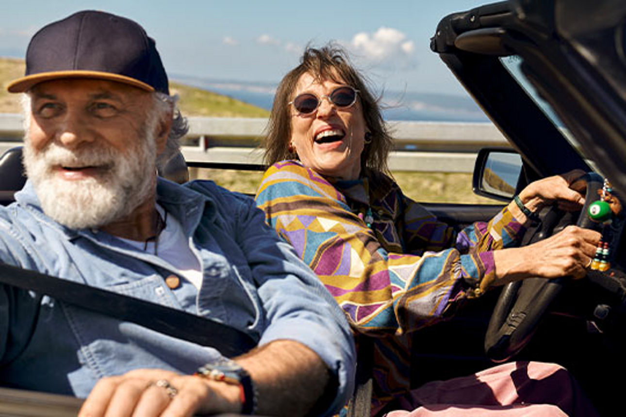 Mann und Frau sitzen lachend im Auto