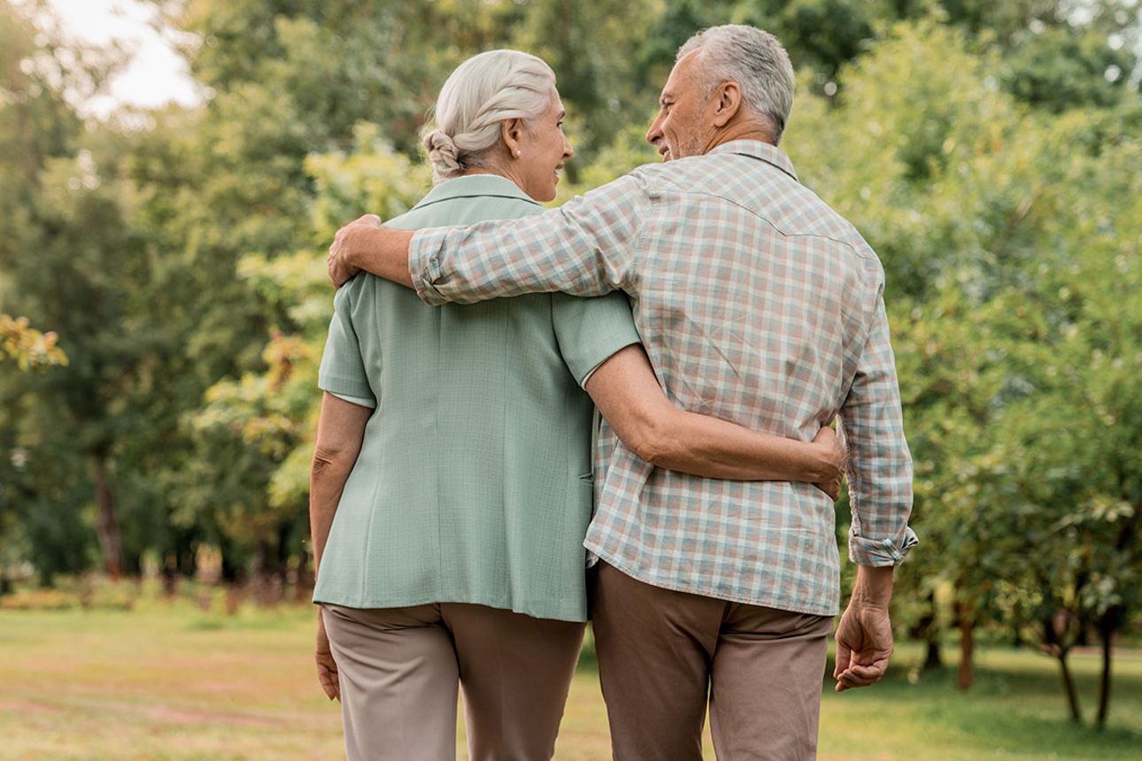 Älteres Paar umarmt sich beim Spaziergang im Park