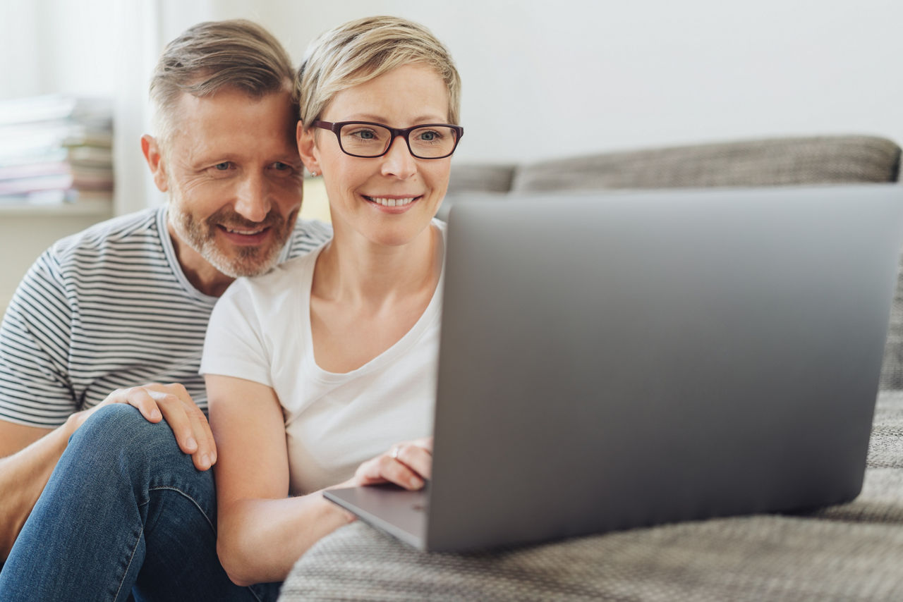 Paar kümmert sich per Laptop um ihre Anschlussfinanzierung