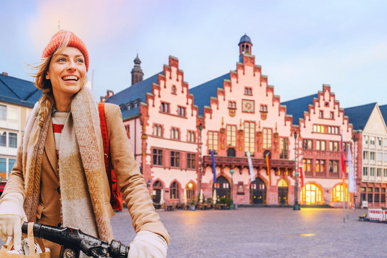 Ein junge blonde Frau auf einem E-Scooter und im Hintergrund der Römer-Platz in Frankfurt am Main.