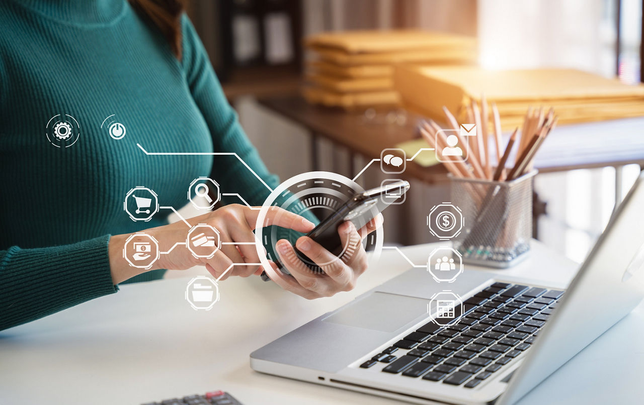 Businesswoman working with smart phone and laptop and digital tablet computer in office with marketing media in virtual icon.