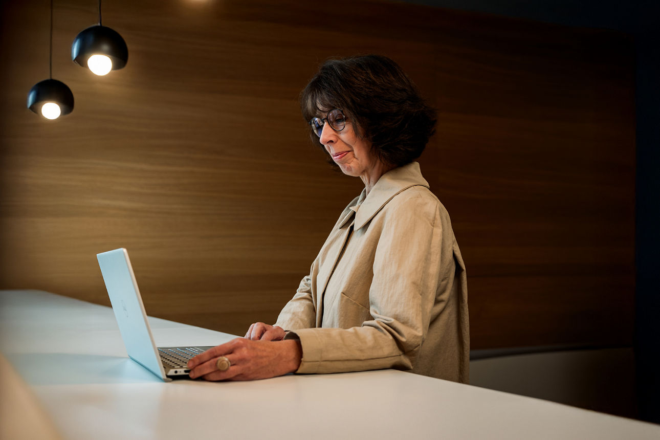 Eine ältere Frau sitzt am Laptop