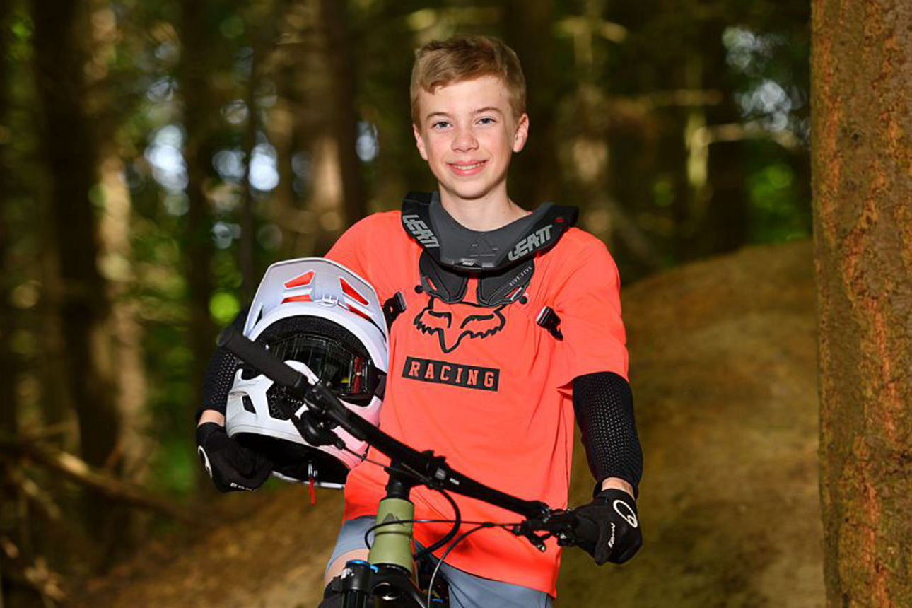Junge posiert mit Mountainbike und Helm