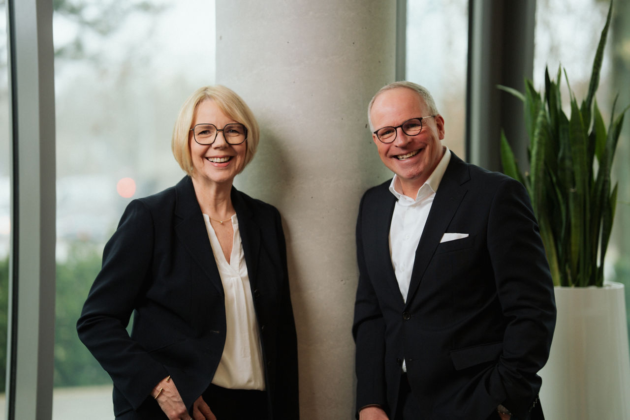 Ein Mann und eine Frau stehen vor einer grünen Wand