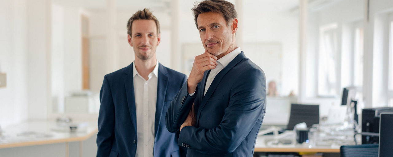 Zwei Männer stehen in einem Büro