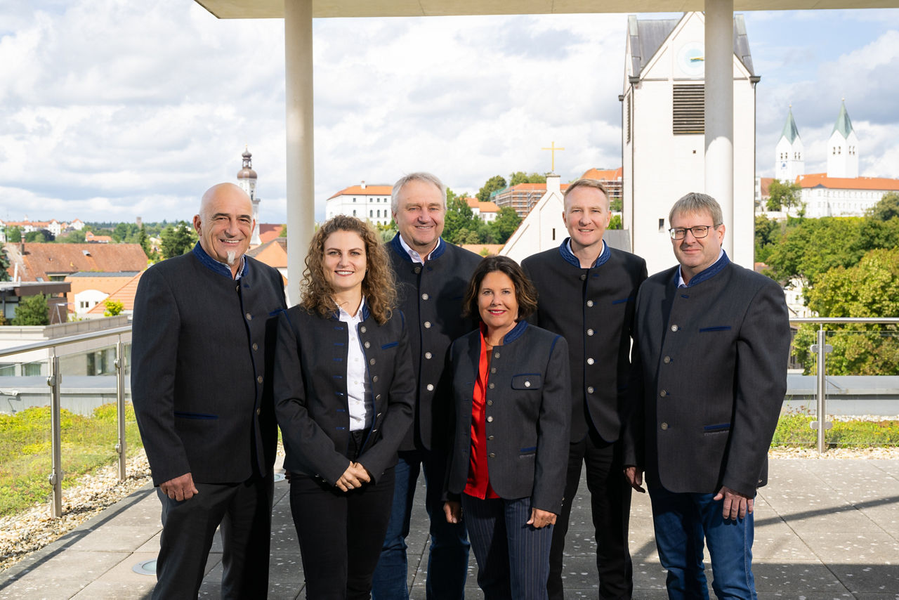 gesamter Aufsichtsrat der FS Bank, zwei Frauen im Vordergrund, vier Männer dahinter, fotografiert auf Dachterrasse mit Blick auf evangelische Kirch und Domberg