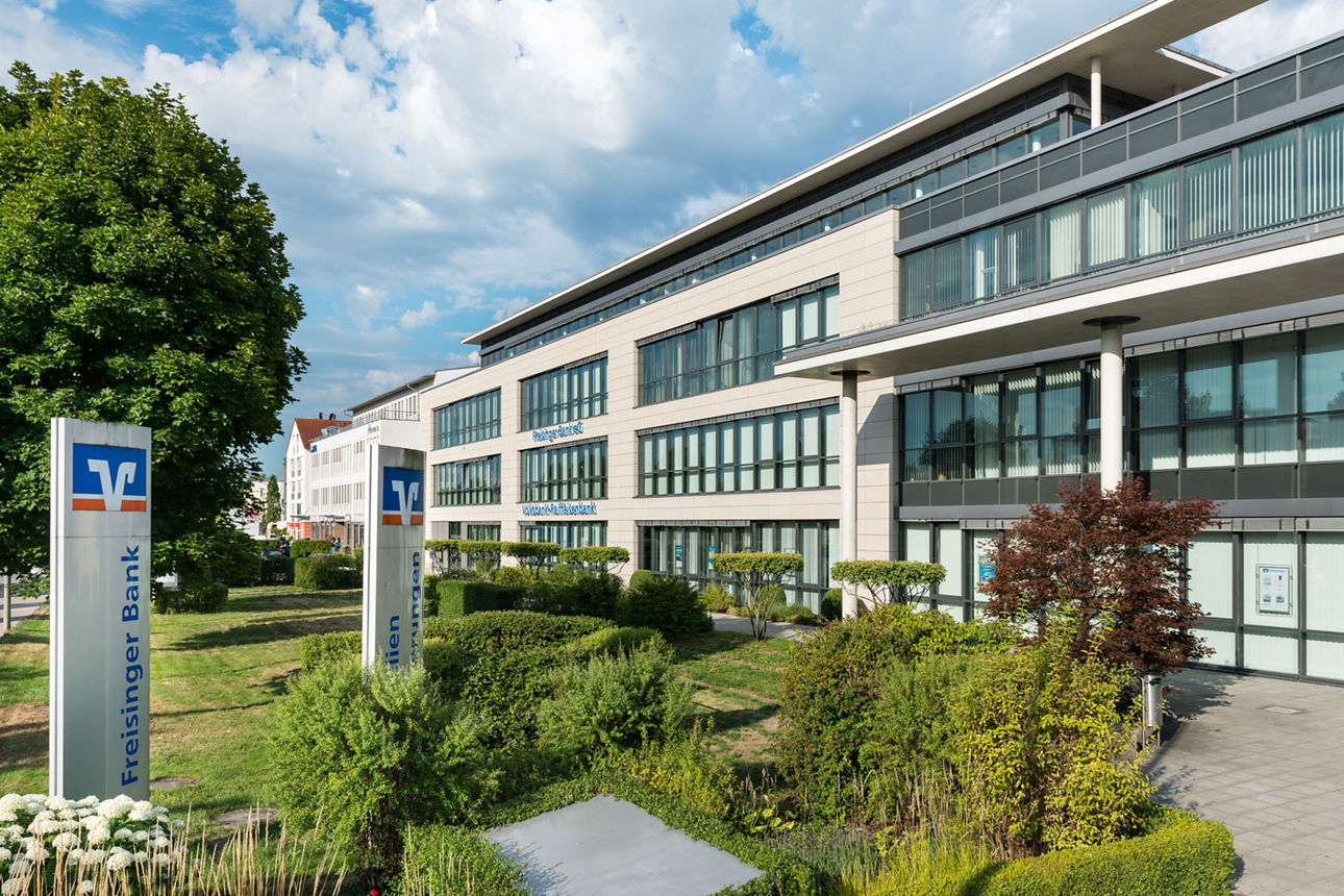 Aussenansicht Hauptstelle Freisinger Bank; moderner Bau mit viel Glasflächen, davor Grünflächen