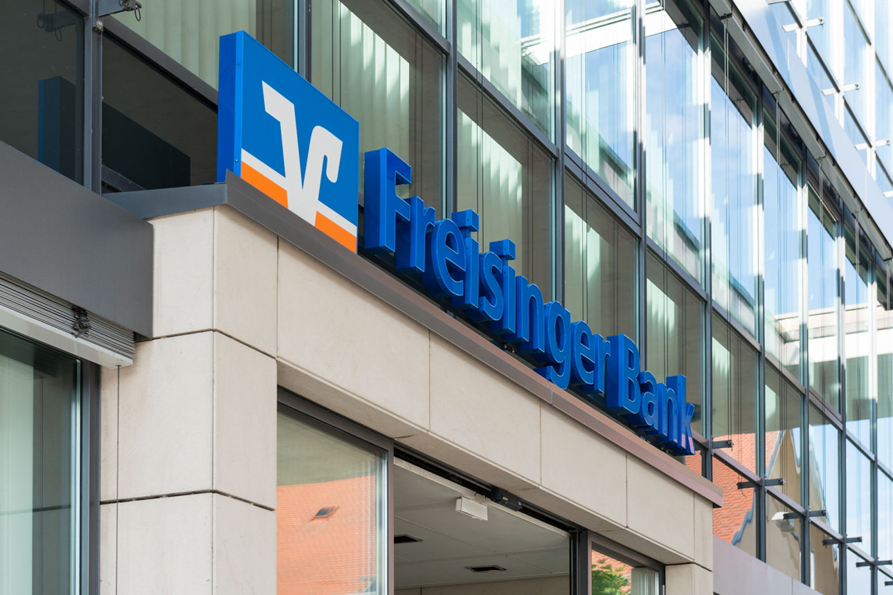 Logo Freisinger Bank über Eingang der Hauptstelle in Freising