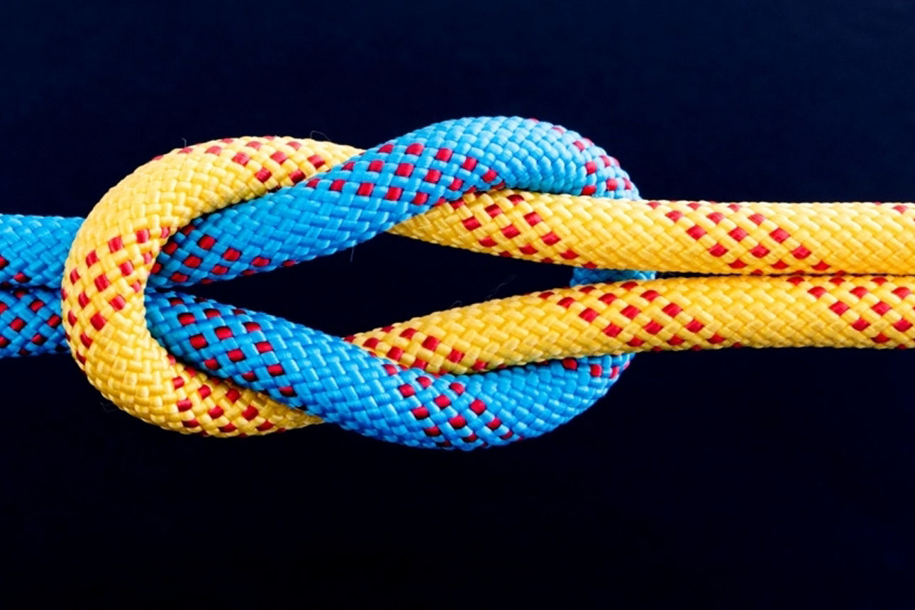Ein blaues und ein oranges Seil durch einen Kreuzknoten verbunden
