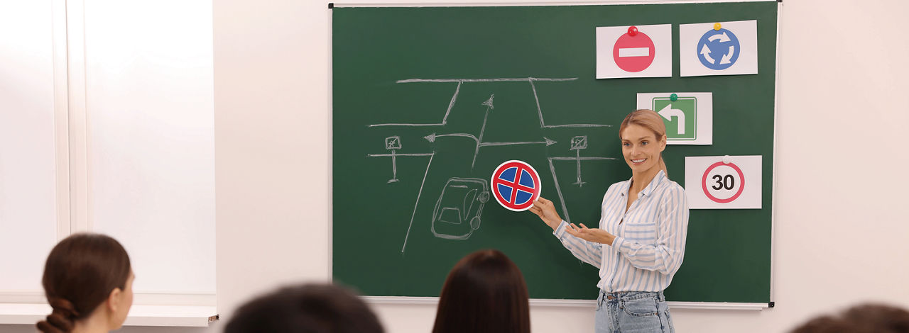 Wie lassen sich die Kosten für den Führerschein senken? Eine Fahrlehrerin erklärt im Theorieunterricht wichtige Inhalte für den Führerschein.