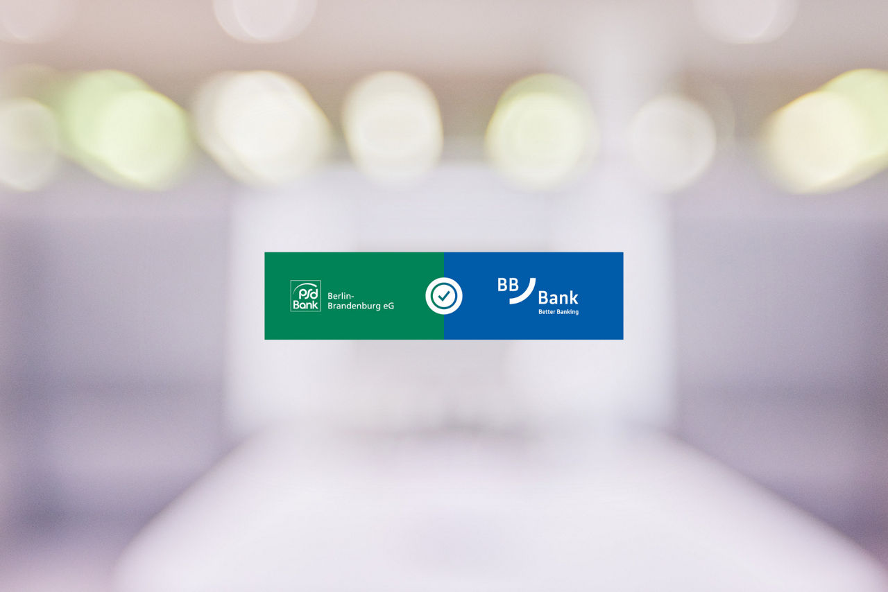 Unscharfer Hintergrund mit Lichtern mit den Logos der PSD Bank Berlin-Brandenburg und der BBBank