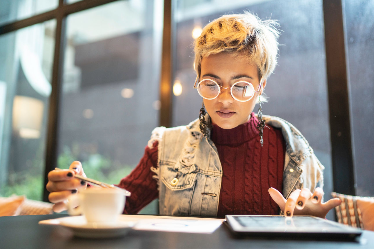 FVB FutureFlex Junge Frau trinkt Kaffee und schaut in ihr Tablet