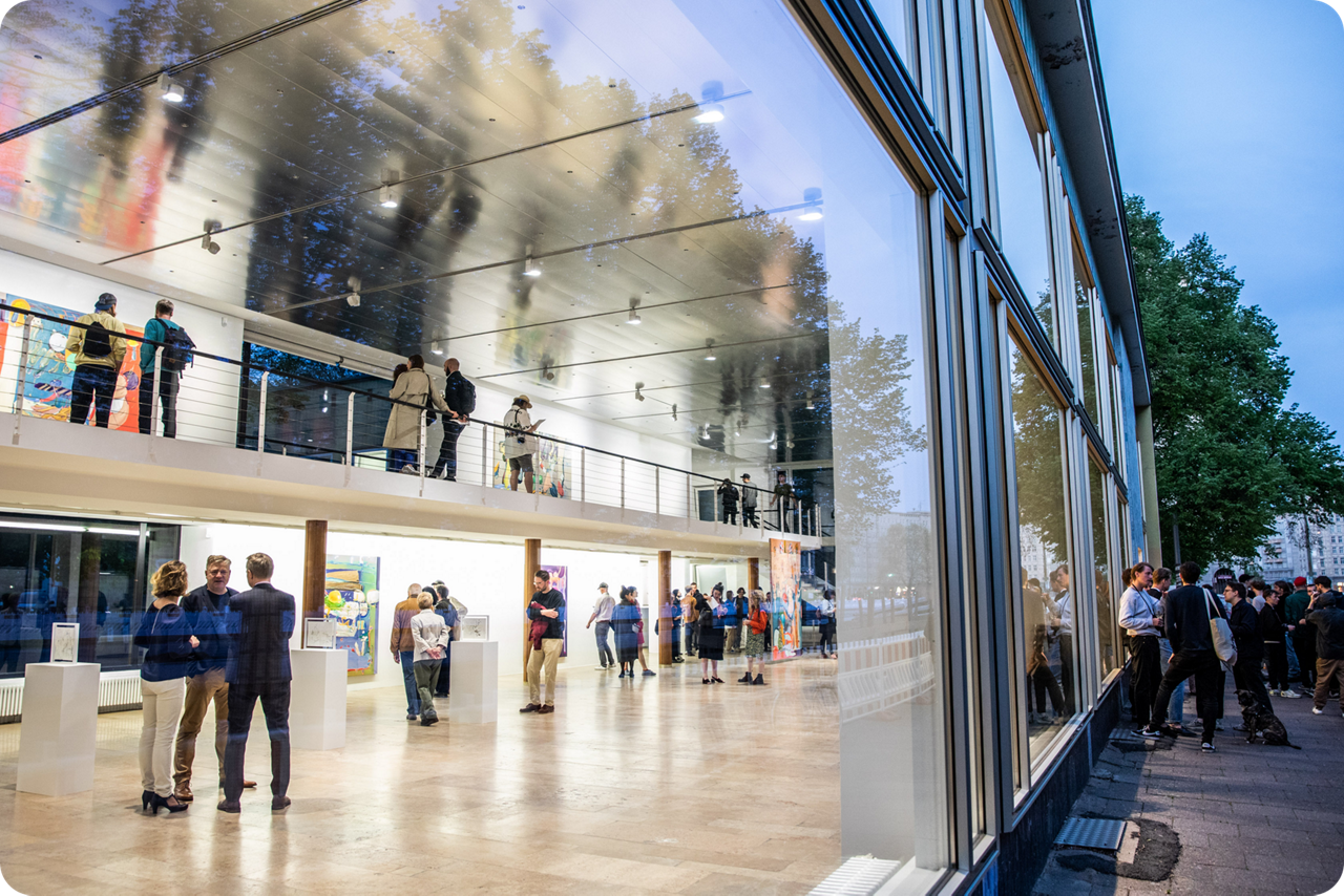 Blick durch eine Schaufensterscheibe auf Galleriebesucher