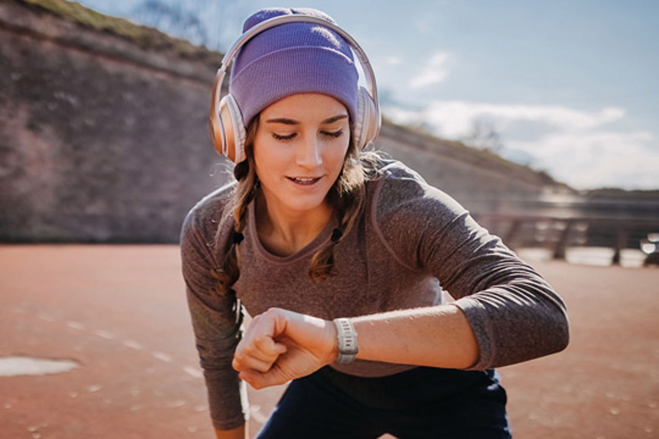 Eine Frau, die auf ihre Uhr schaut