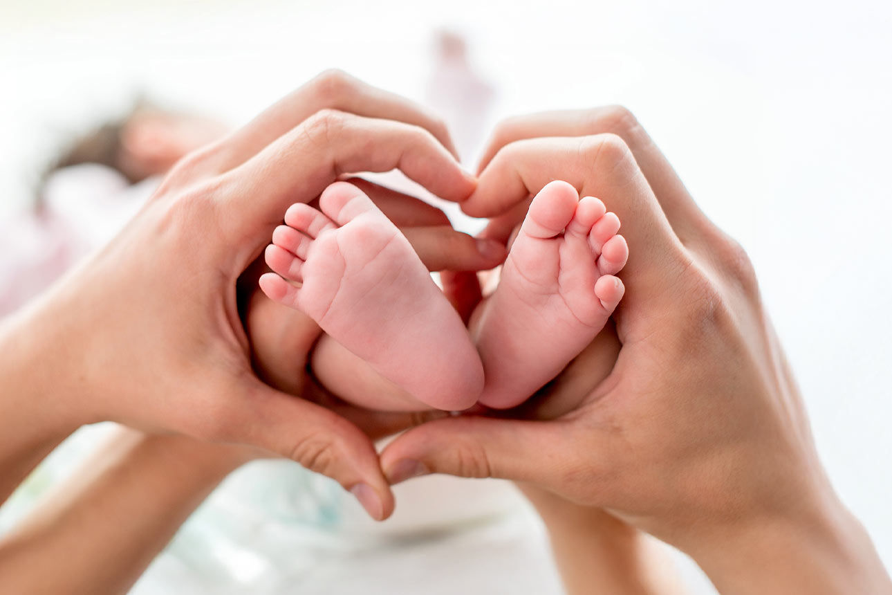 Nahaufnahme eines Babys welches auf seiner Mutter liegt