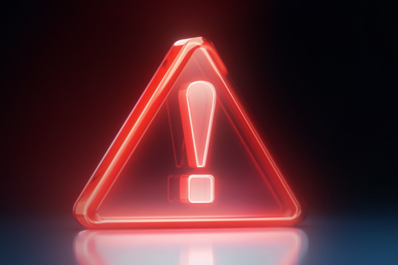 Leuchtendes rotes Gefahrensymbol vor blau-schwarzem Hintergrund