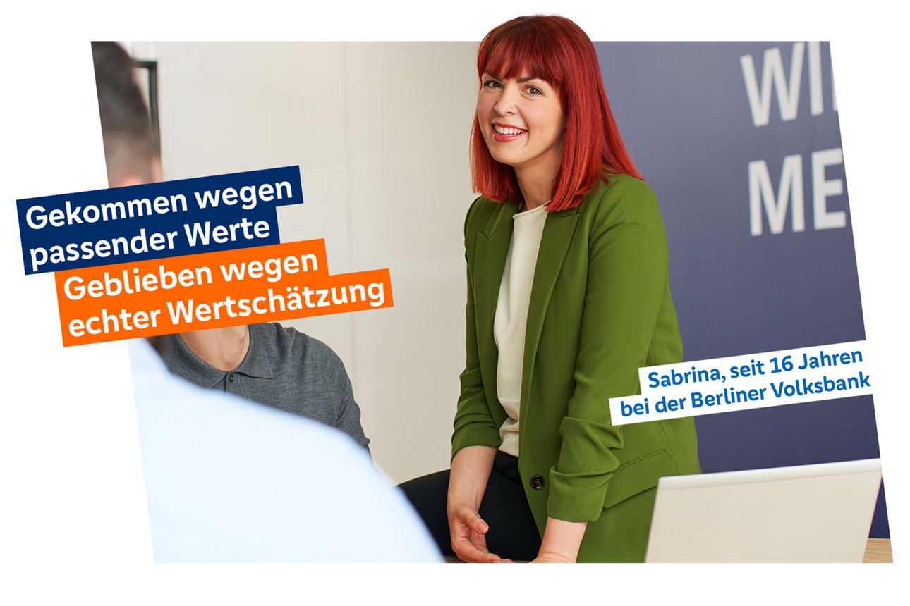 Frau sitzt auf Schreibtisch und lächelt