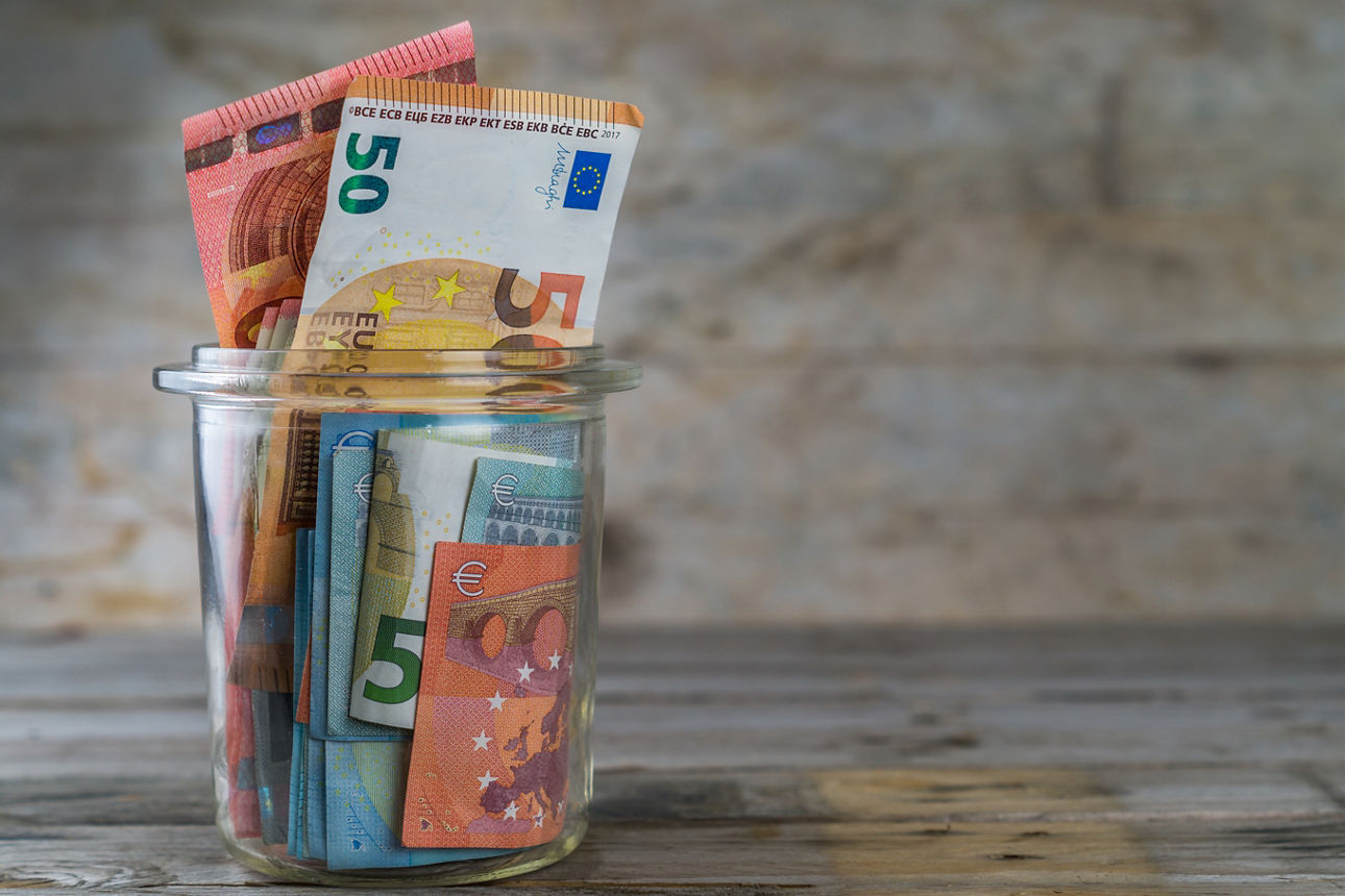 Glas gefüllt mit Euroscheinen 