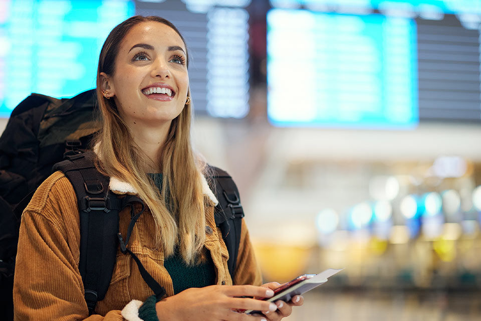 Reisende Person mit Rucksack am Flughafen