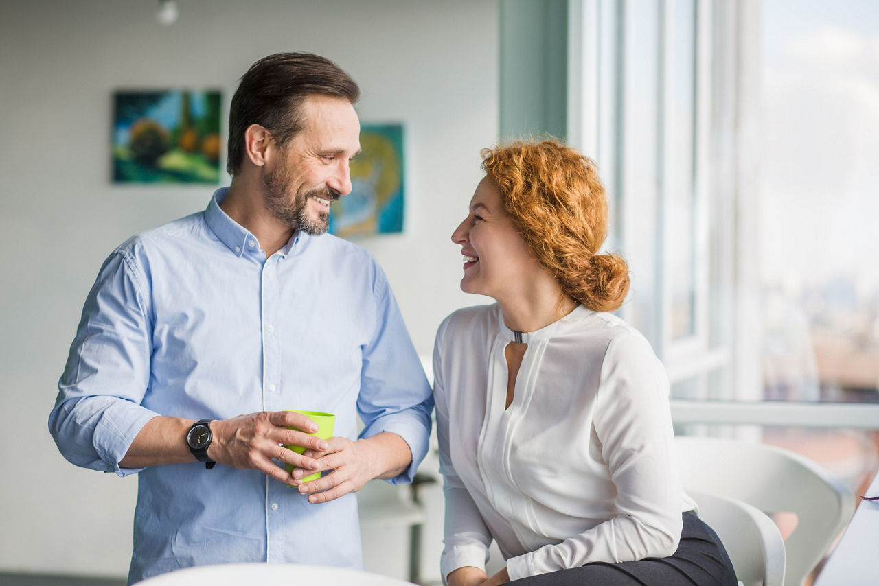Eine Frau und ein Mann freuen sich über die professionelle Geldanlagen-Beratung 