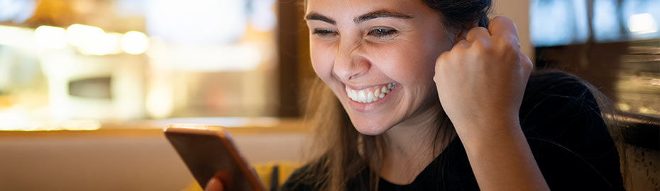 Eine junge Frau mit langen dunklen Haaren sitzt in einem Café