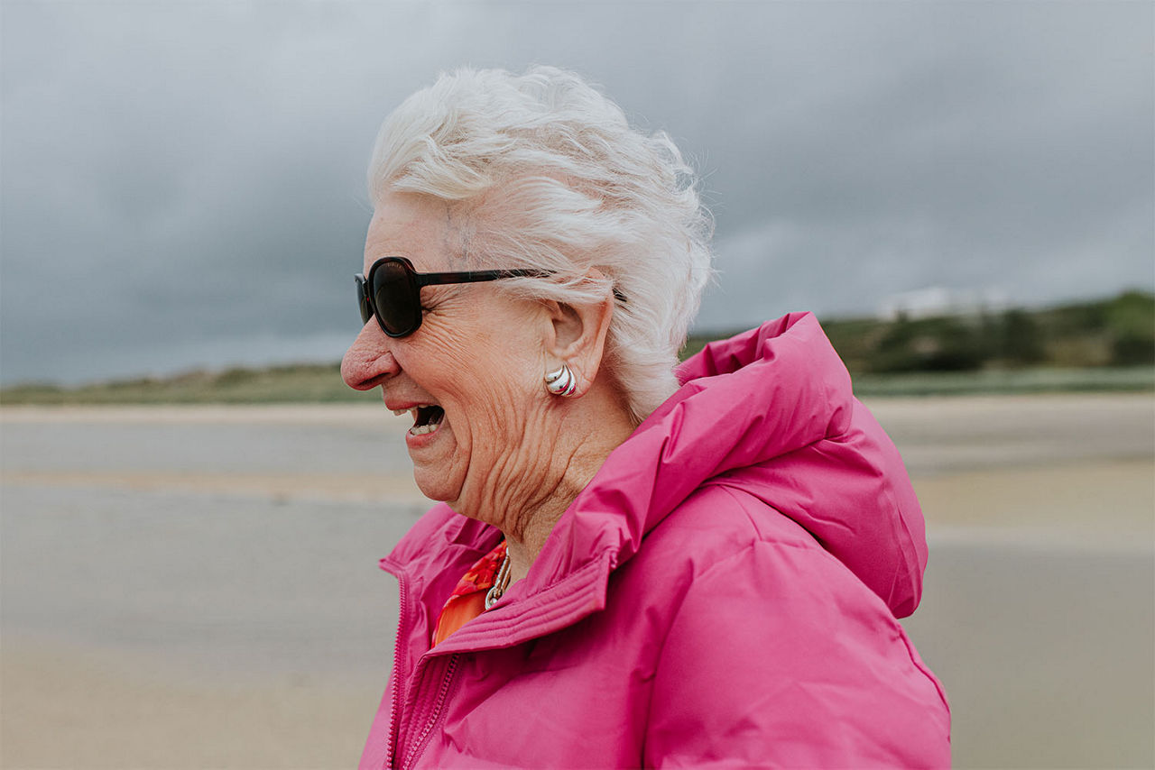 Ältere Frau mit einem Grinsen am Strand