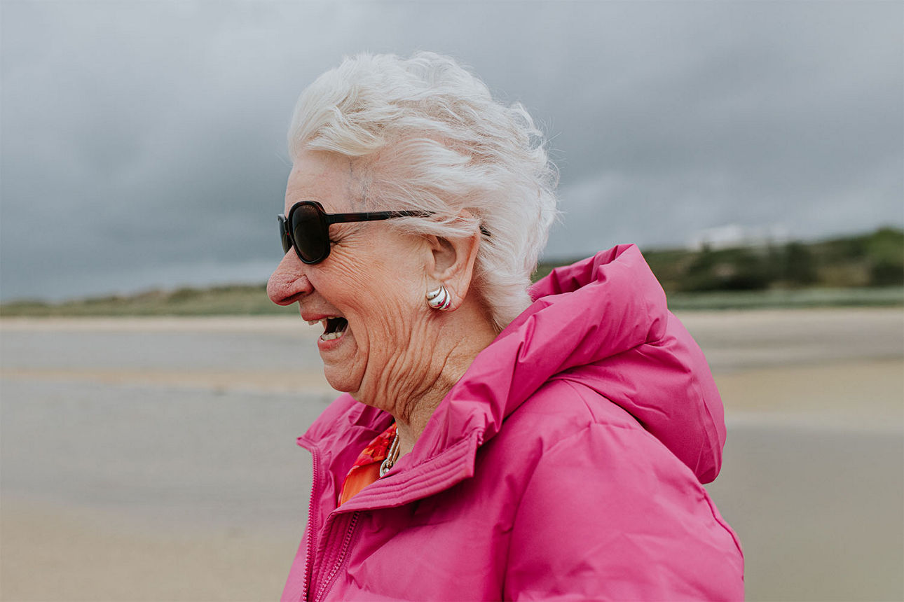 Ältere Frau mit einem Grinsen am Strand
