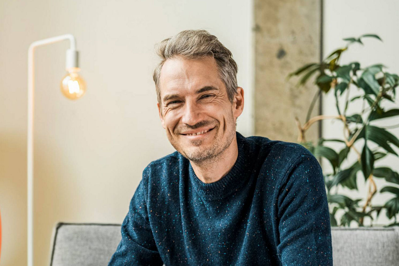 Mann lächelnd auf der Couch