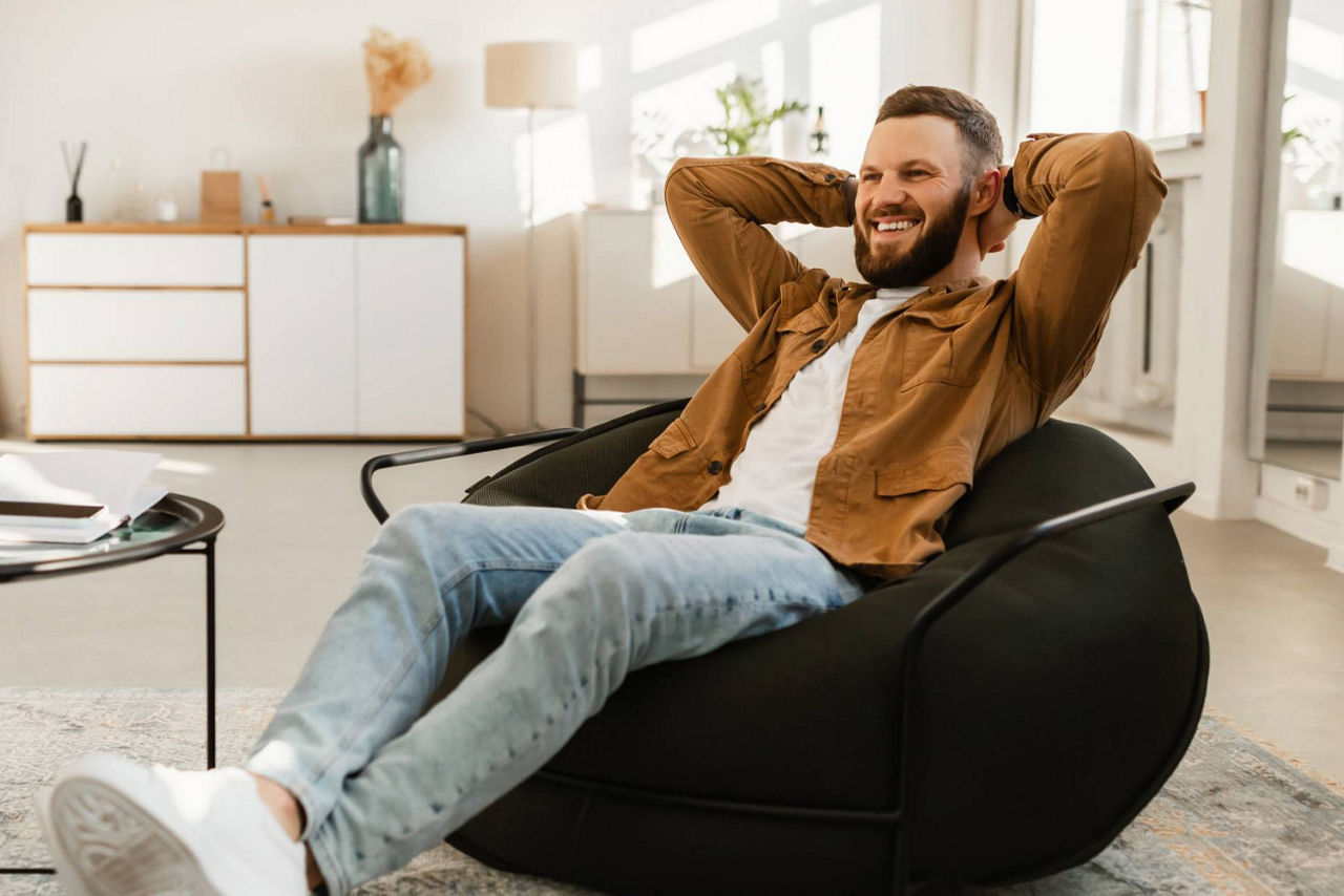 Junger Mann sitzt entspannt auf einem Sitzssack