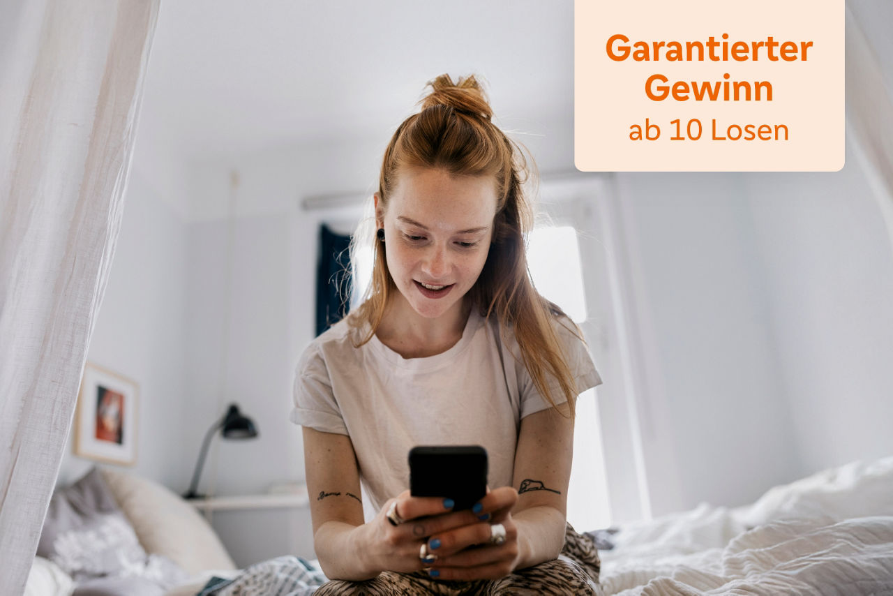 Junge Frau sitzt an der Bettkante und schaut gespannt in ihr Handy mit einem Hinweis "Garantierter Gewinn ab 10 Losen"