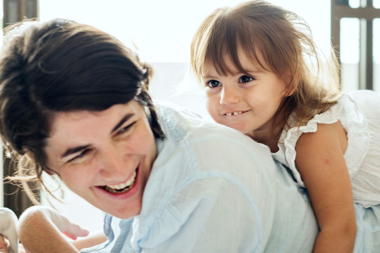 Mutter mit ihrer Tochter auf dem Rücken