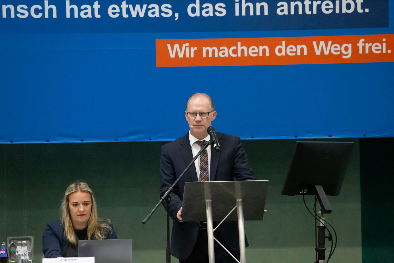 Ein Mann hält einen Vortrag vor einer Menschenmenge.