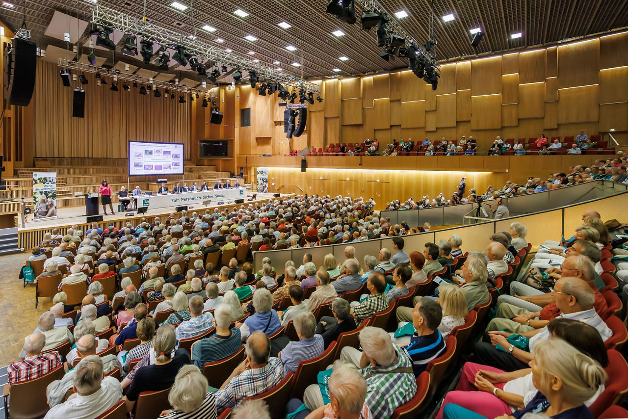 Teilnehmende der Generalversammlung verfolgen Rede des PSD Vorstands