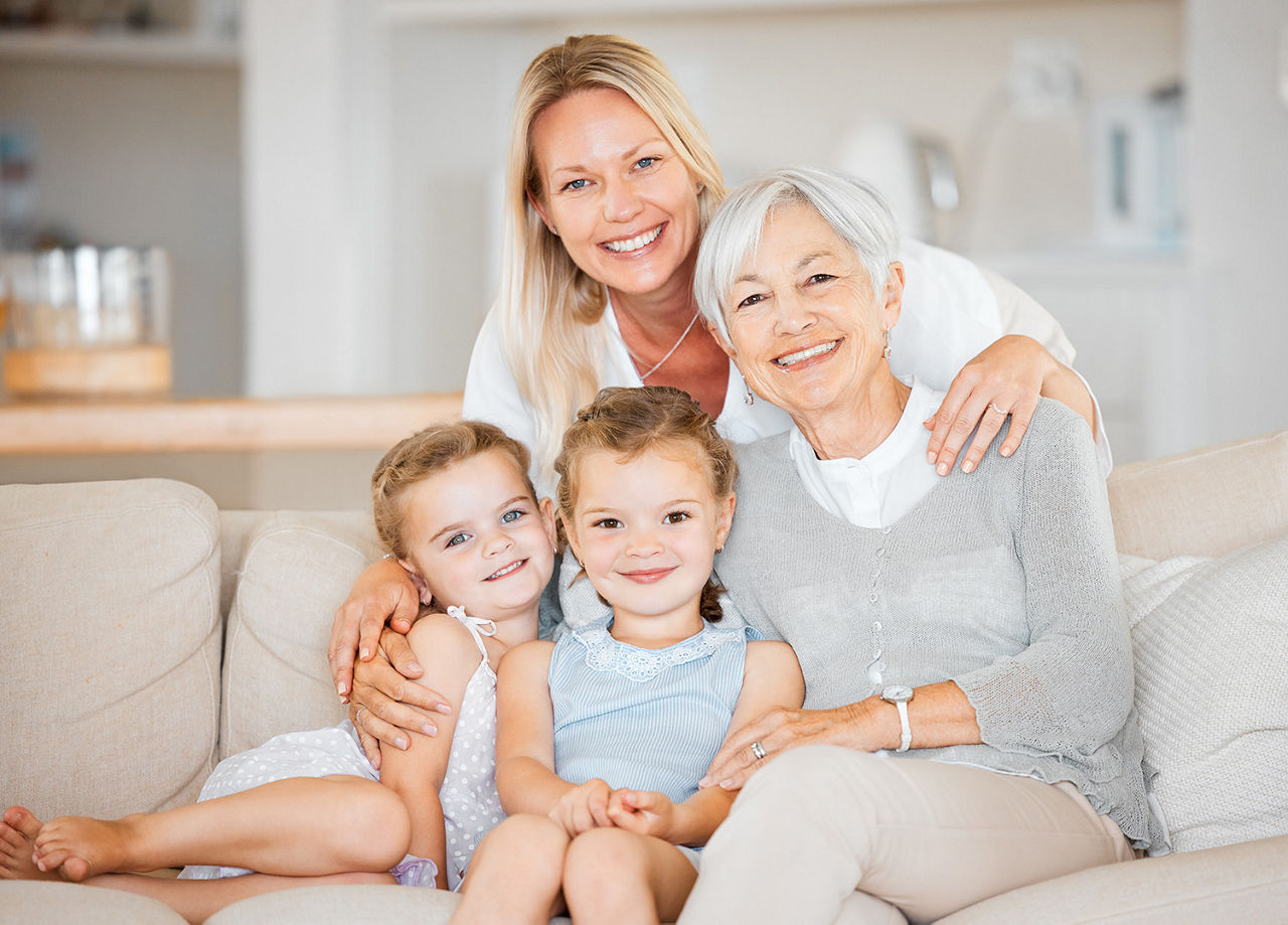 Drei Generationen Frauen sitzen auf dem Sofa