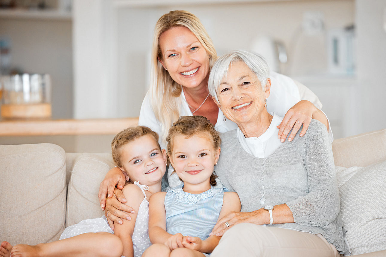 Drei Generationen Frauen sitzen auf dem Sofa