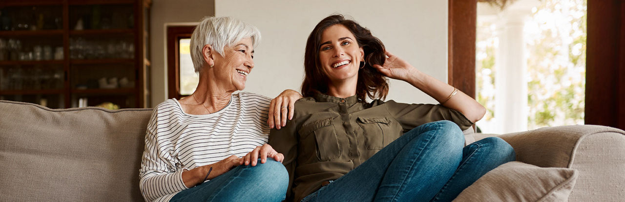 Eine Mutter und ihrer Tochter sitzen nebeneinander  auf einem Sofa
