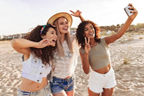 Drei junge Frauen am Strand machen ein Selfie