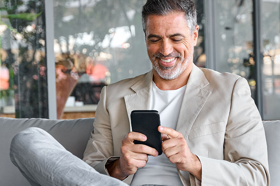 Ein sitzender Mann schaut auf sein Handy