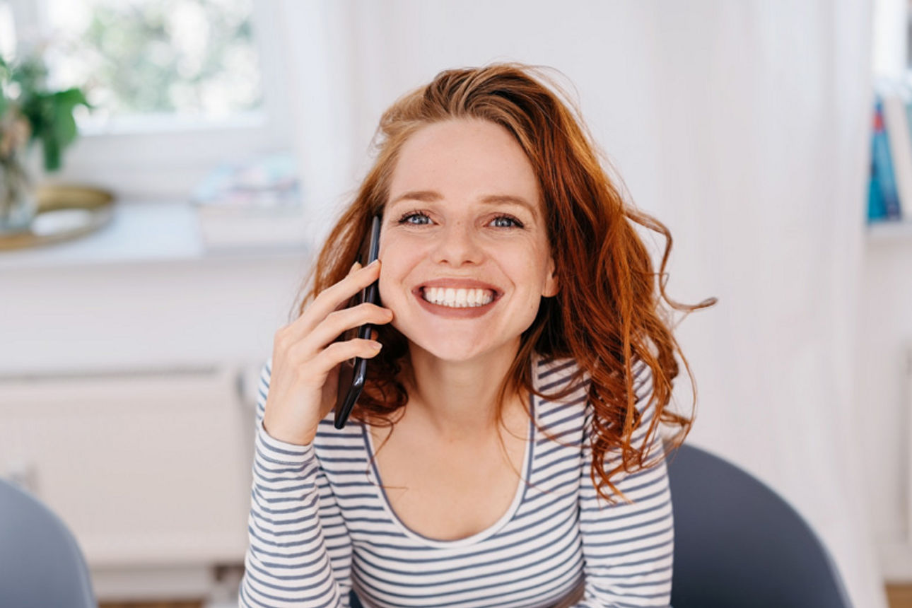 Frau telefoniert lächelnd