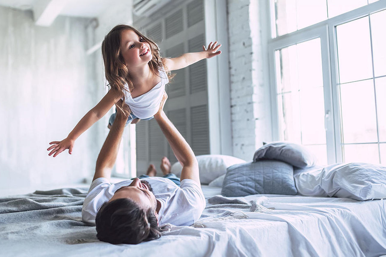 Mann an einem Schreibtisch schaut in einen Laptop und lehnt sich entspannt zurück