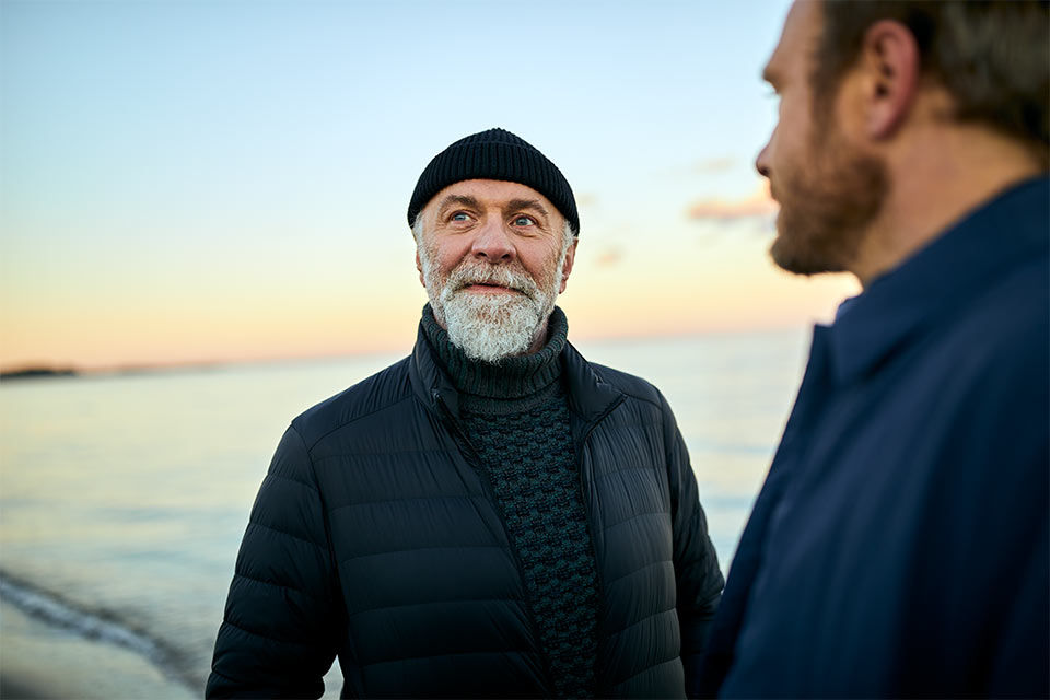 Zwei Männer im Gespräch am Meer