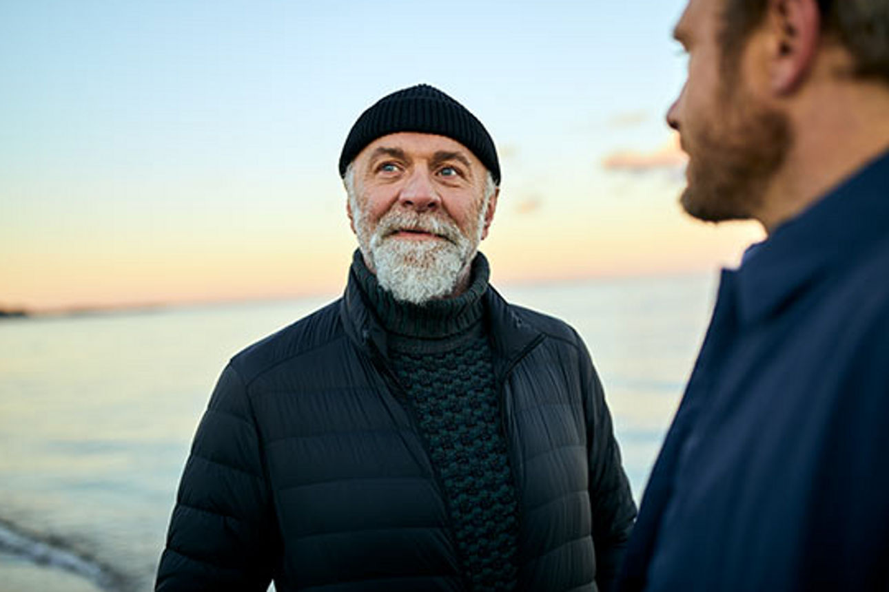 Zwei Männer stehen am Strand und unterhalten sich