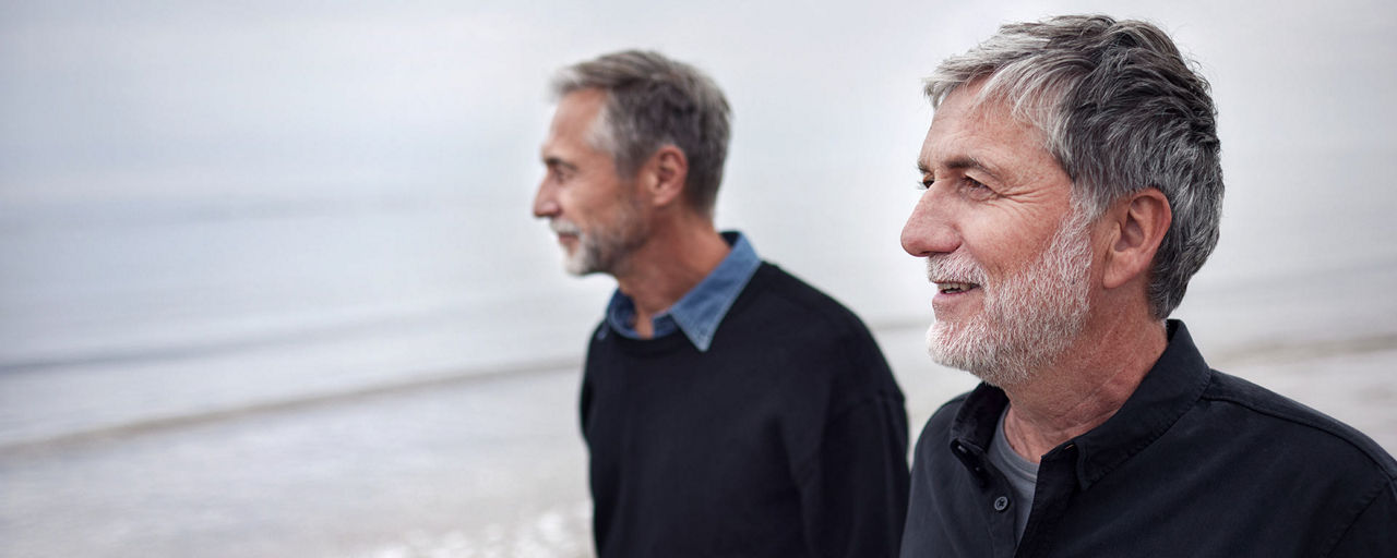 Zwei Männer im Gespräch beim Spaziergang auf dem Strand