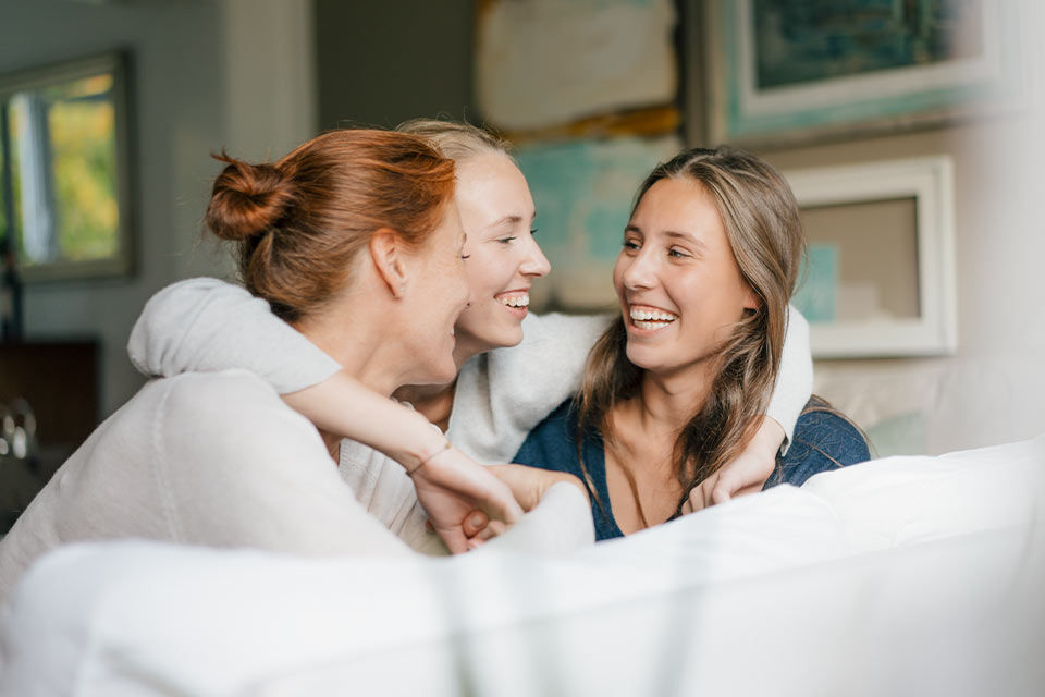 Eine Frau legt die Arme um zwei weitere Frauen