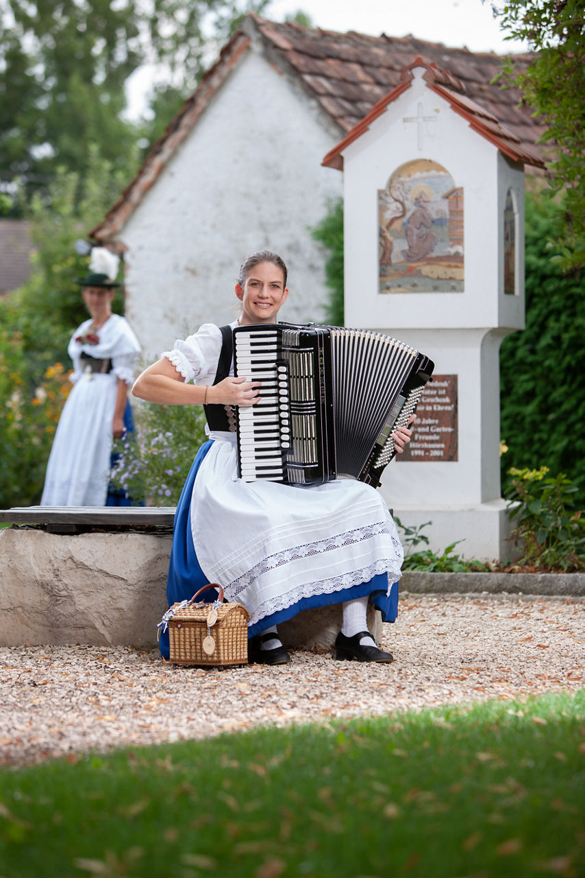 zwei Frauen in traditioneller Tracht spielen ein Musikinstrument