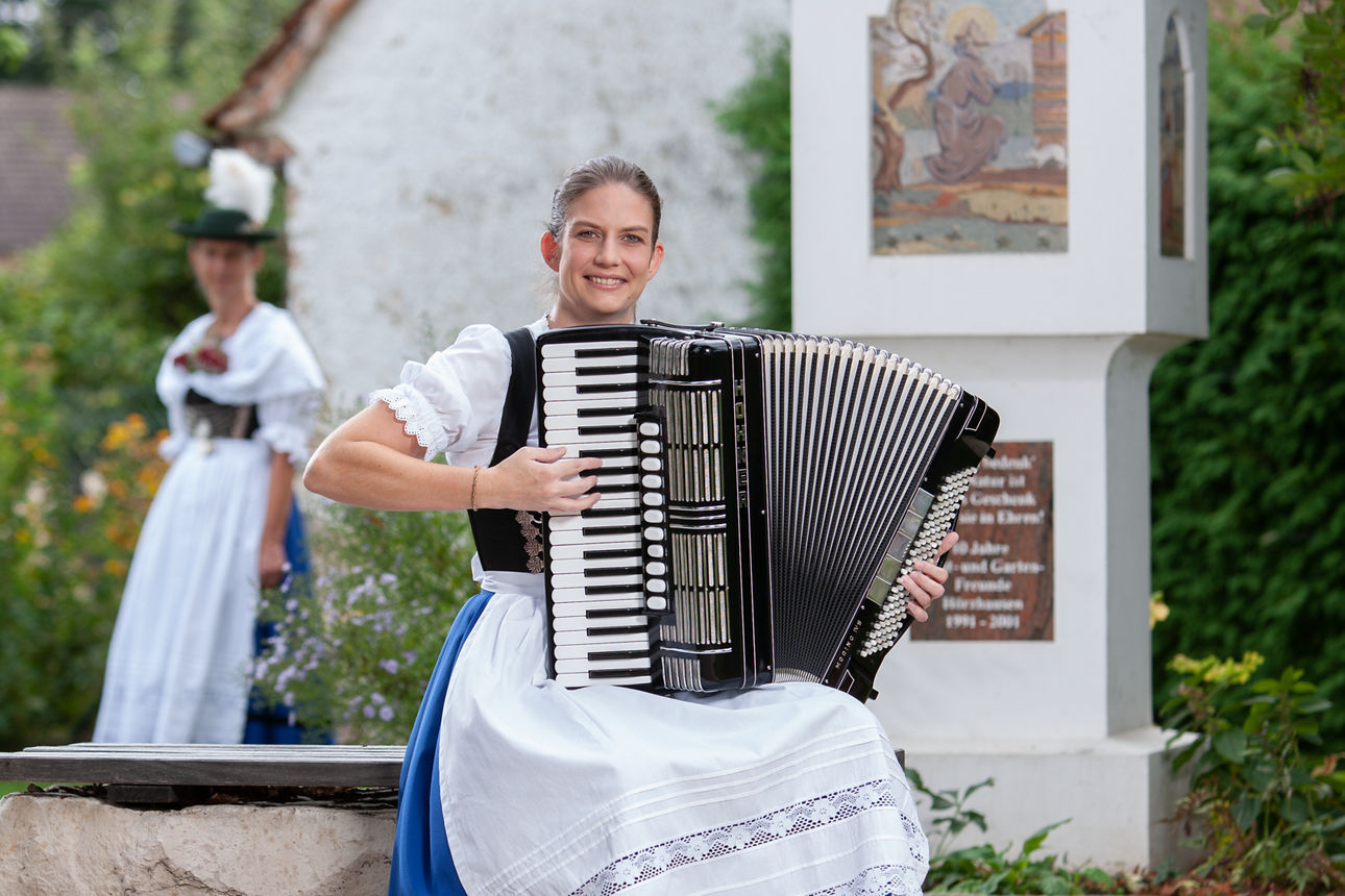 zwei Frauen in traditioneller Tracht spielen ein Musikinstrument