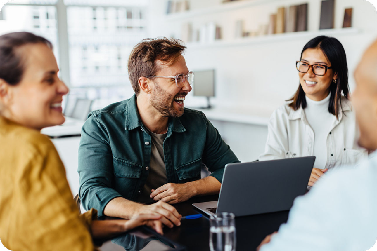 Vier Personen sitzen an einem Tisch und eröffnen ein Geschäftskonto